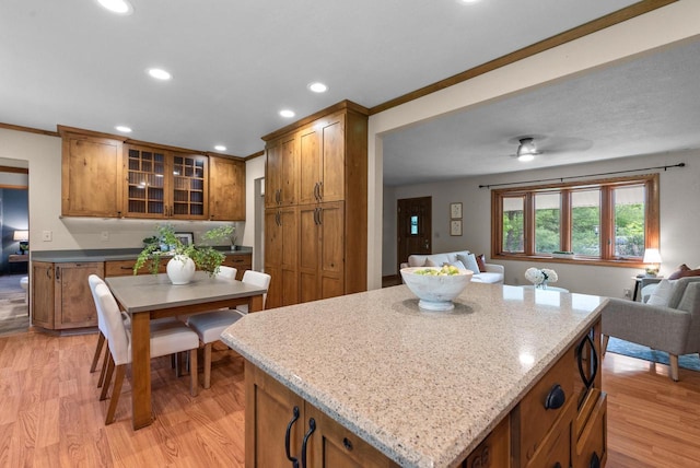 W188N10115 Maple Rd, Germantown, WI 53022 - kitchen featuring brown cabinetry, light wood-style floors, open floor plan, glass insert cabinets, and recessed lighting