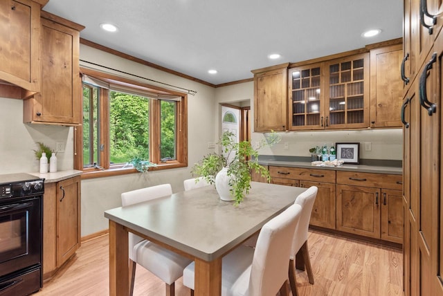 W188N10115 Maple Rd, Germantown, WI 53022 - kitchen featuring black range oven, brown cabinetry, light wood-style flooring, crown molding, and glass insert cabinets