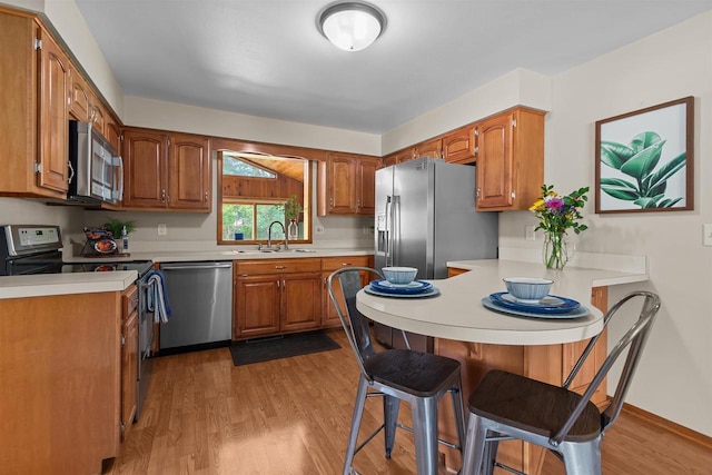 1001 S Matthias St, Appleton, WI 54915 - kitchen with stainless steel appliances, a sink, a peninsula, a breakfast bar area, and light countertops
