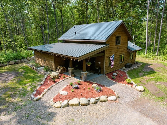 12008 US Highway 63, Hayward, WI 54843 - view of front of house featuring a wooded view, driveway, and metal roof