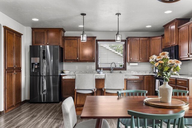 W6708 Prescott Dr, Greenville, WI 54942 - kitchen with fridge with ice dispenser, dark wood finished floors, light countertops, black microwave, and decorative light fixtures