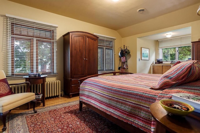 1705 Emerson St, Beloit, WI 53511 - bedroom featuring light wood-type flooring, radiator heating unit, and lofted ceiling
