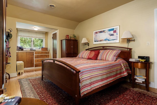 1705 Emerson St, Beloit, WI 53511 - bedroom featuring radiator heating unit, wood finished floors, and lofted ceiling