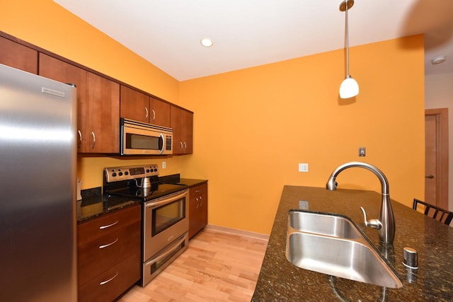 601 E Ogden Ave Unit 411, Milwaukee, WI 53202 - kitchen with appliances with stainless steel finishes, a sink, light wood-type flooring, pendant lighting, and brown cabinets