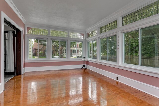 543 N Durkee St, Appleton, WI 54911 - unfurnished sunroom featuring crown molding, baseboards, and wood finished floors