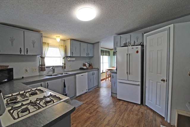 302 Lakeshore Dr, Avoca, WI 53506 - kitchen with white appliances, a textured ceiling, healthy amount of natural light, dark wood-type flooring, and dark countertops