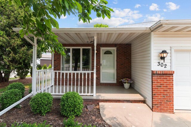 302 Parkside Ct, Kimberly, WI 54136 - view of exterior entry with a porch, brick siding, and a garage