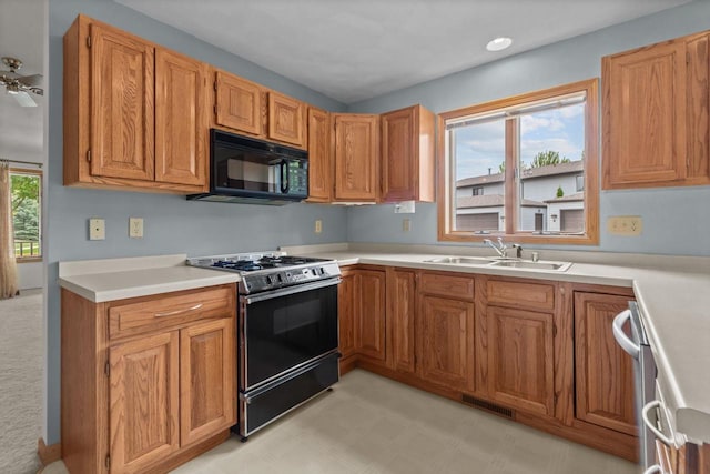 302 Parkside Ct, Kimberly, WI 54136 - kitchen featuring black microwave, gas stove, a sink, light countertops, and brown cabinetry