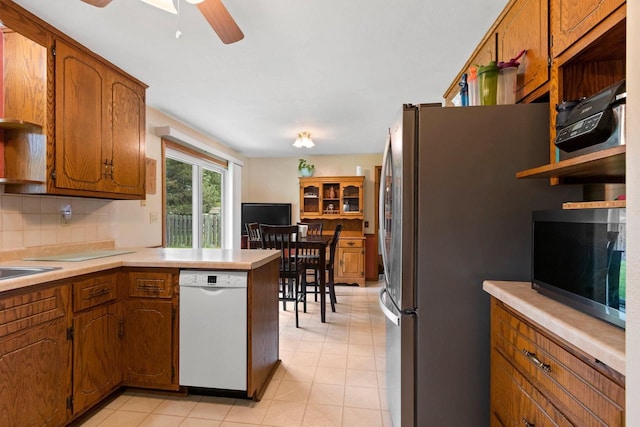 57 Solar Cir, Appleton, WI 54915 - kitchen with white dishwasher, black microwave, freestanding refrigerator, tasteful backsplash, and a peninsula
