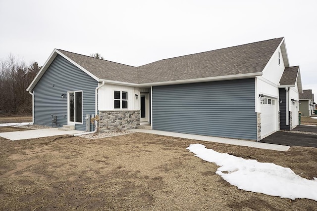 910-920 Green Pastures Trl, Plover, WI 54467 - rear view of property with entry steps, an attached garage, stone siding, and roof with shingles