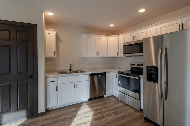 910-920 Green Pastures Trl, Plover, WI 54467 - kitchen featuring stainless steel appliances, a sink, white cabinets, light countertops, and dark wood-style flooring