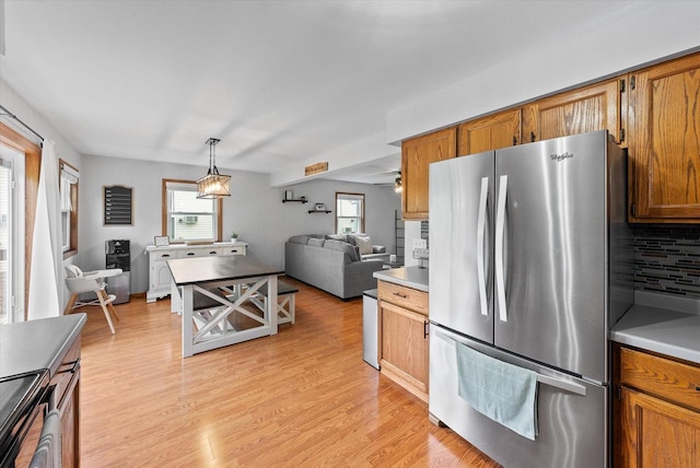 1529 Vogt Dr, West Bend, WI 53095 - kitchen with freestanding refrigerator, open floor plan, plenty of natural light, and light wood finished floors