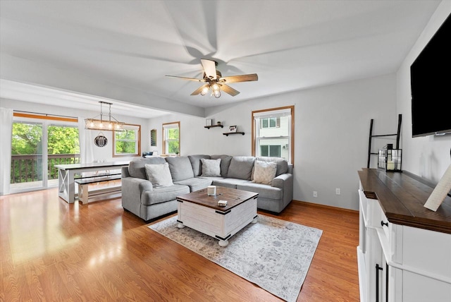 1529 Vogt Dr, West Bend, WI 53095 - living area featuring a ceiling fan, light wood-type flooring, a chandelier, and baseboards