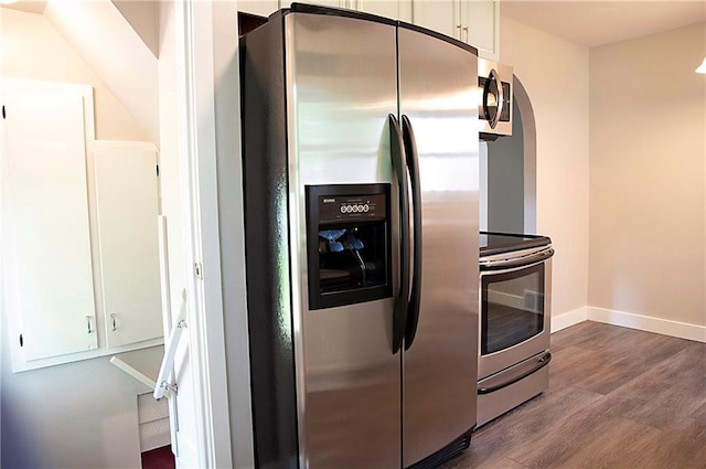 121 Pear St, Chippewa Falls, WI 54729 - kitchen featuring stainless steel appliances, dark wood-style floors, white cabinetry, baseboards, and arched walkways