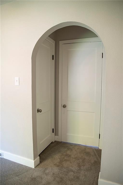 121 Pear St, Chippewa Falls, WI 54729 - hall with carpet, baseboards, and arched walkways
