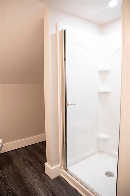 121 Pear St, Chippewa Falls, WI 54729 - bathroom featuring a shower stall, wood finished floors, toilet, and baseboards