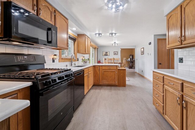249 Donovan Cir, Rosendale, WI 54974 - kitchen featuring black appliances, a sink, a peninsula, tasteful backsplash, and light countertops