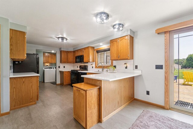 249 Donovan Cir, Rosendale, WI 54974 - kitchen with black appliances, washer / dryer, a peninsula, and tasteful backsplash