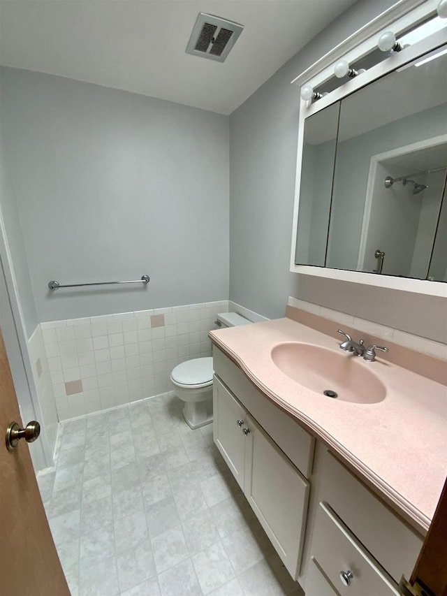 874 E Petunia Ln, Beloit, WI 53511 - bathroom featuring vanity, tile walls, and wainscoting