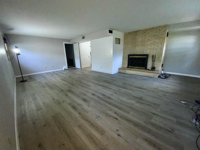 874 E Petunia Ln, Beloit, WI 53511 - unfurnished living room with wood finished floors and a brick fireplace