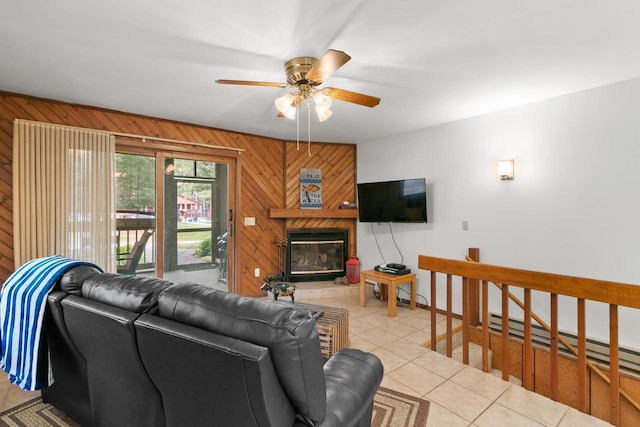 1251 Canyon Rd Unit 40, Wisconsin Dells, WI 53965 - living room featuring wood walls, ceiling fan, light tile patterned floors, a baseboard heating unit, and a glass covered fireplace