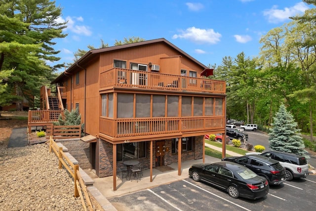 1251 Canyon Rd Unit 40, Wisconsin Dells, WI 53965 - back of property with uncovered parking, stairs, a sunroom, a patio area, and stone siding