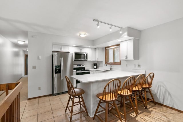 1251 Canyon Rd Unit 40, Wisconsin Dells, WI 53965 - kitchen with stainless steel appliances, a sink, a peninsula, a breakfast bar area, and white cabinets