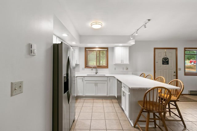 1251 Canyon Rd Unit 40, Wisconsin Dells, WI 53965 - kitchen featuring appliances with stainless steel finishes, a sink, a peninsula, a kitchen bar, and light tile patterned floors