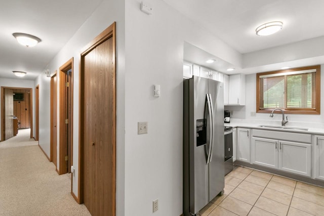 1251 Canyon Rd Unit 40, Wisconsin Dells, WI 53965 - kitchen with stainless steel appliances, a sink, light countertops, white cabinetry, and light tile patterned flooring