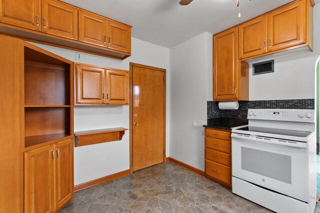 1013 28th St, Two Rivers, WI 54241 - kitchen with white range with electric stovetop, decorative backsplash, ceiling fan, baseboards, and brown cabinetry