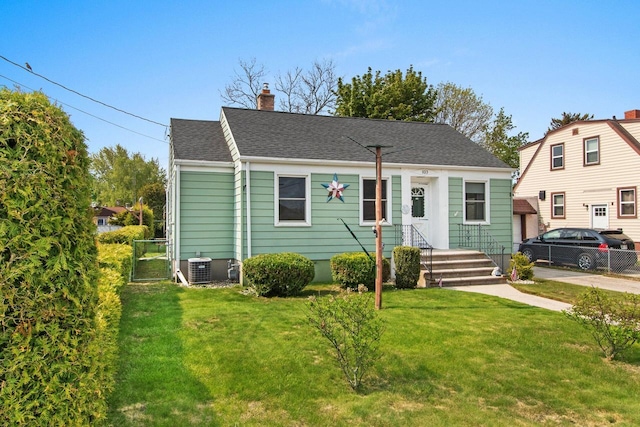 1013 28th St, Two Rivers, WI 54241 - view of front facade with a chimney, a shingled roof, and central AC