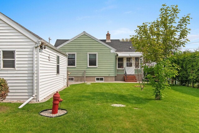 1013 28th St, Two Rivers, WI 54241 - rear view of house with a yard and a chimney