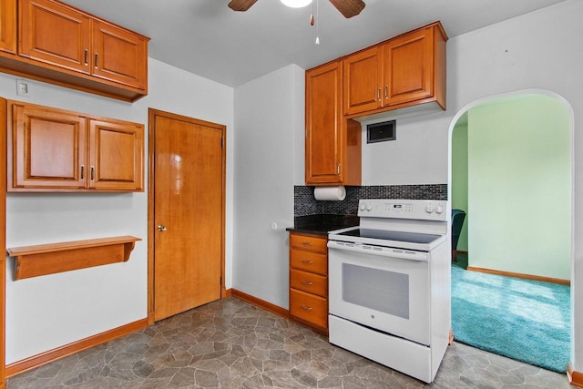 1013 28th St, Two Rivers, WI 54241 - kitchen with white electric range, a ceiling fan, brown cabinetry, and tasteful backsplash