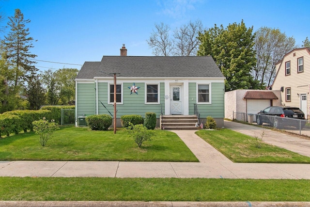 1013 28th St, Two Rivers, WI 54241 - view of front facade with a chimney, a shingled roof, and central air condition unit