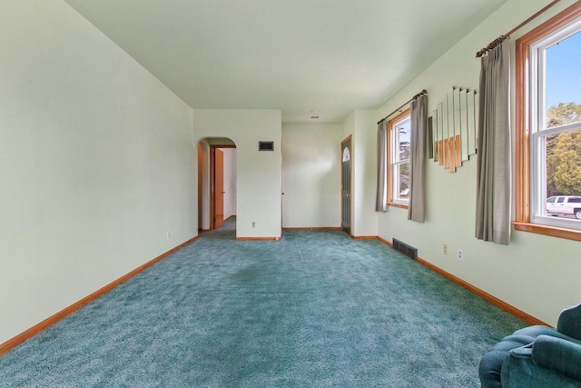 1013 28th St, Two Rivers, WI 54241 - unfurnished living room with arched walkways, baseboards, and carpet flooring