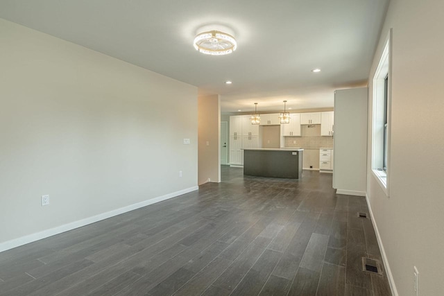 600 8th Ave, New Glarus, WI 53574 - unfurnished living room featuring baseboards, dark wood-style floors, recessed lighting, and a chandelier