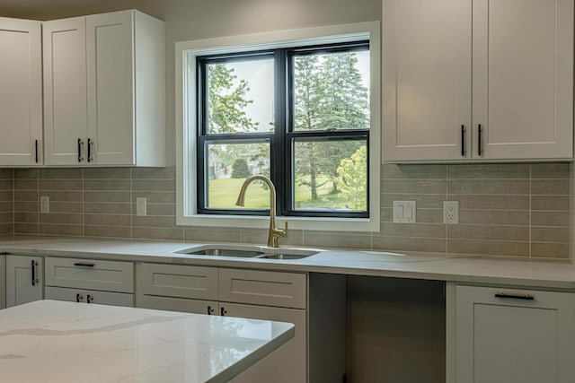600 8th Ave, New Glarus, WI 53574 - kitchen featuring a sink, white cabinets, light stone counters, and tasteful backsplash