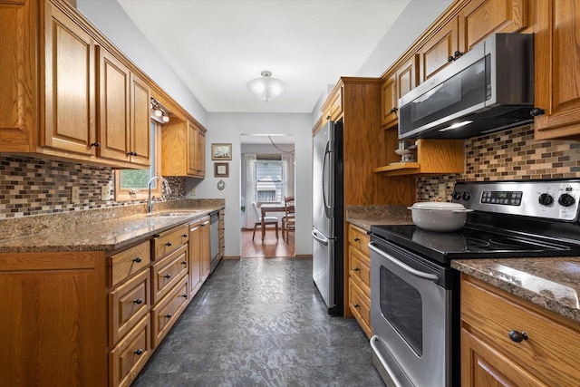8317 S 42nd St, Franklin, WI 53132 - kitchen with appliances with stainless steel finishes, brown cabinets, tasteful backsplash, and dark stone counters