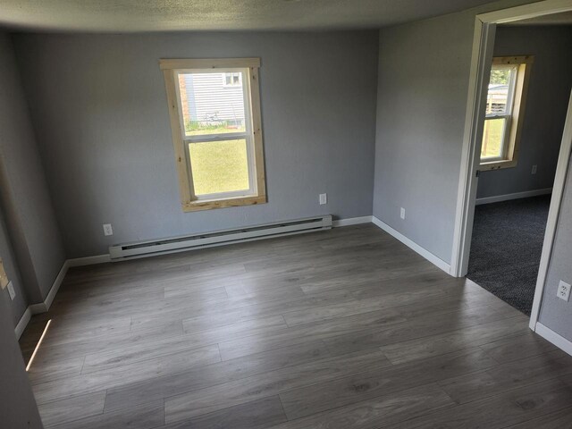 547 S Cambridge St, Wautoma, WI 54982 - empty room with a baseboard radiator, healthy amount of natural light, baseboards, and dark wood-style floors