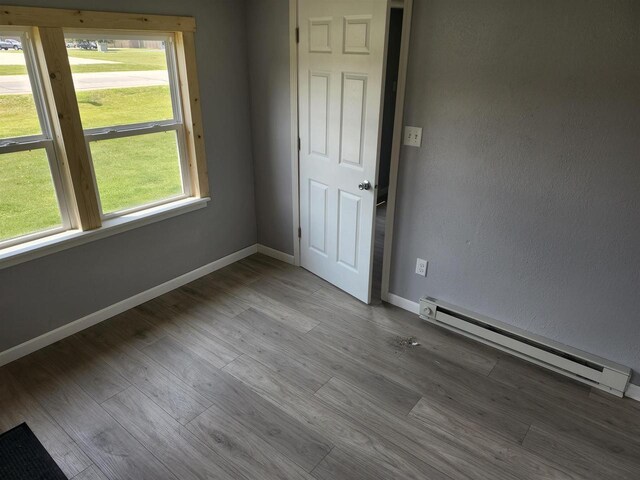 547 S Cambridge St, Wautoma, WI 54982 - unfurnished room featuring baseboard heating, baseboards, and wood finished floors