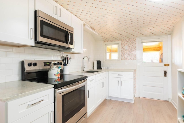 W4943 County Rd S, Horicon, WI 53032 - kitchen featuring appliances with stainless steel finishes, a sink, white cabinets, and light wood-type flooring