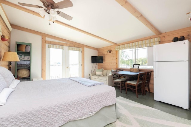 W4943 County Rd S, Horicon, WI 53032 - bedroom with freestanding refrigerator, wooden walls, french doors, access to outside, and concrete floors
