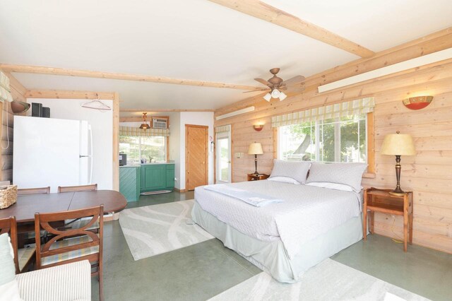 W4943 County Rd S, Horicon, WI 53032 - bedroom with freestanding refrigerator, finished concrete flooring, wood walls, multiple windows, and beamed ceiling