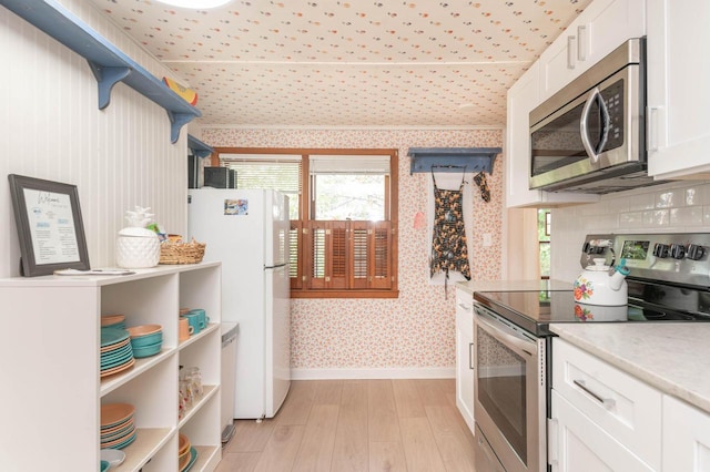 W4943 County Rd S, Horicon, WI 53032 - kitchen with appliances with stainless steel finishes, wallpapered walls, open shelves, light wood-type flooring, and white cabinets