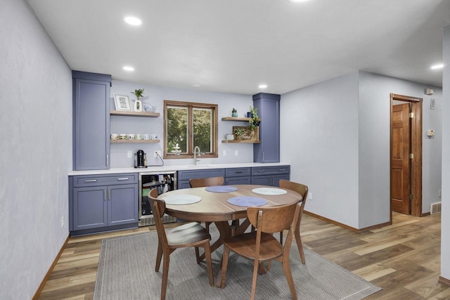 6500 E Decorah Ave, Oshkosh, WI 54902 - dining space with wine cooler, light wood-style floors, recessed lighting, baseboards, and bar