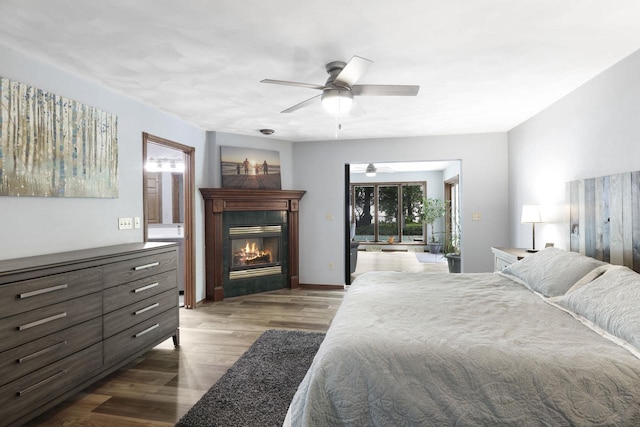6500 E Decorah Ave, Oshkosh, WI 54902 - bedroom featuring wood finished floors, access to outside, a glass covered fireplace, and ceiling fan