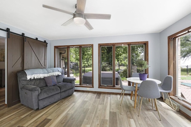 6500 E Decorah Ave, Oshkosh, WI 54902 - living room featuring a barn door, light wood-type flooring, and a ceiling fan