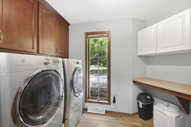 6500 E Decorah Ave, Oshkosh, WI 54902 - washroom with cabinet space, independent washer and dryer, light wood-style floors, and baseboards