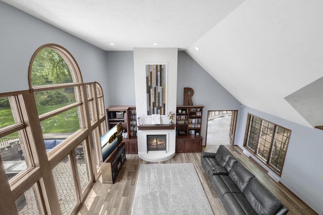 6500 E Decorah Ave, Oshkosh, WI 54902 - living room with a fireplace, wood finished floors, vaulted ceiling, and recessed lighting
