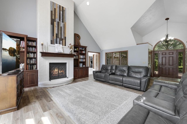 6500 E Decorah Ave, Oshkosh, WI 54902 - living room featuring high vaulted ceiling, a chandelier, wood finished floors, and a brick fireplace